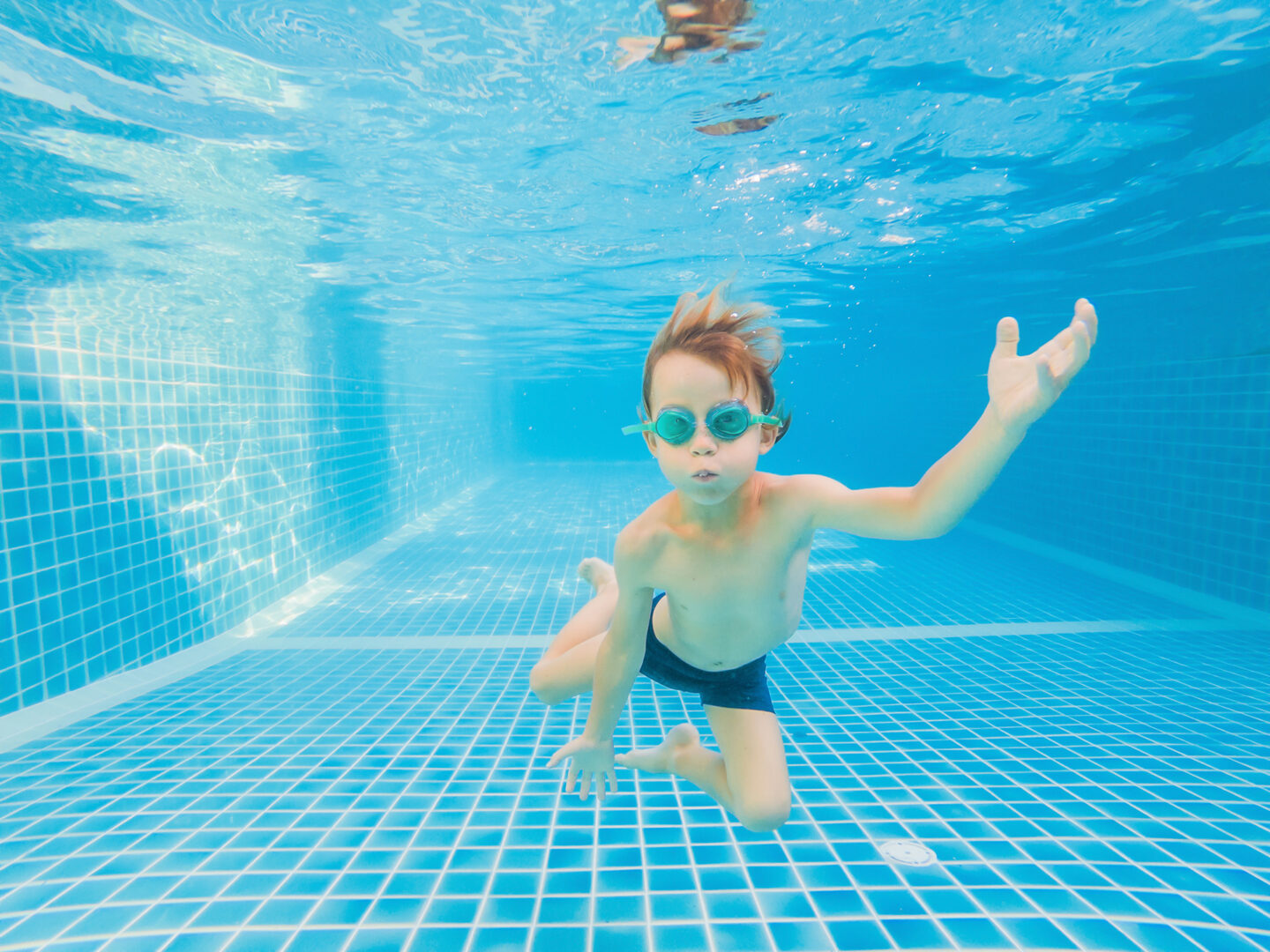 underwater young boy fun swimming pool with goggles summer vacation fun at Aquafin